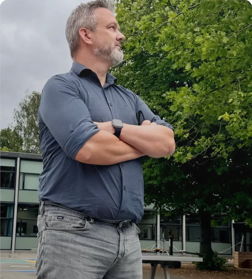 Skoleleder Joachim Kjølberg står med korslagte arme i skolegården på Brøndbyvester Skole.
