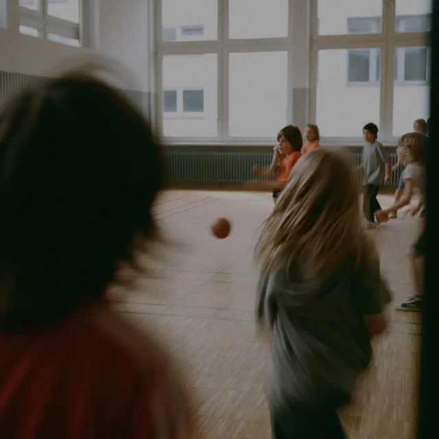 Elever leger med en bold i en gymnastiksal.